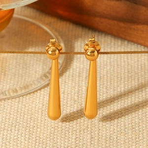 Macro detail of polished 18K gold plated stainless steel teardrop dangle earrings
