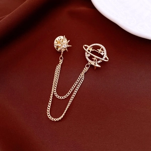 Detailed macro of 18k gold butterfly brooch with crystal stars and delicate chain