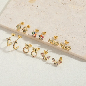Gros plan sur les boucles d'oreilles dorées 14K avec zircon coloré et motifs floraux