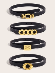 Detail of four black skinny belts featuring diverse golden buckles on a clean background