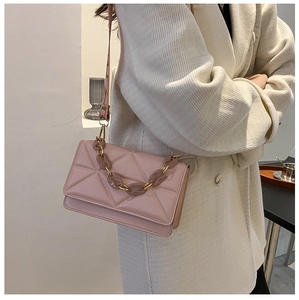 Detailed view of pink quilted handbag featuring resin chain and metal buckle