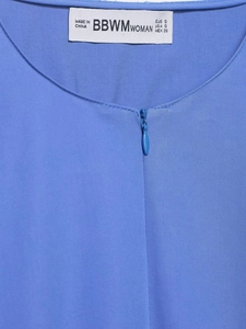 Détail de l'encolure en popeline bleue avec fermeture éclair invisible et texture tissu