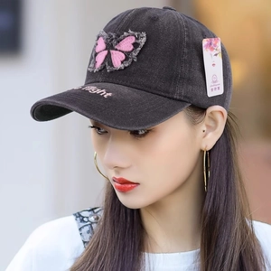 Denim baseball cap with pink butterfly patch and flight embroidery on gray fabric