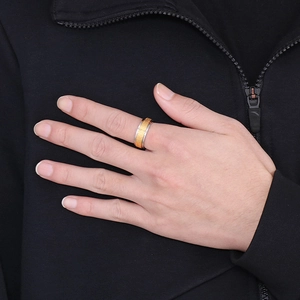 Detail of male model wearing a two-tone gold and silver rotatable stainless steel cross ring