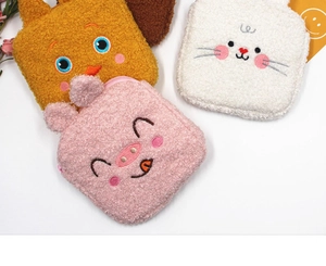 Close-up of animal embroidery and soft plush texture on small portable storage bags
