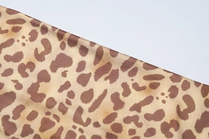 Detailaufnahme der glatten Leopardenmuster-Stofftextur und des Tiermusters auf dem Kleid
