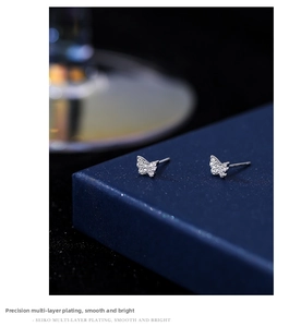 Macro shot of silver butterfly stud earring with sparkling cubic zirconia on jewelry box
