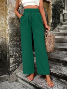 Détail du pantalon large vert foncé avec taille élastique à cordon et poches à boutons