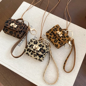 Macro detail of three leopard print mini pouch pendants with gold metal clasps