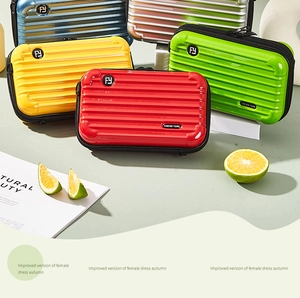 Colorful mini hard-shell suitcase bags with grooved texture and circular logo detail