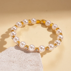 Détail du bracelet en perles avec entretoises dorées et anneaux en zircon sur pierre