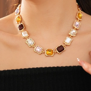 Detailed view of vintage gold necklace featuring multi-colored square crystals and hammered texture