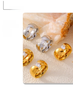 Nahaufnahme von klobigen Gold- und Silberringen mit Zirkonia-Steinen auf Steinsockel