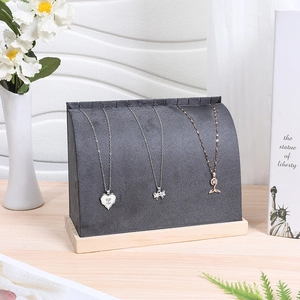 Grey velvet necklace display stands with wooden base featuring three elegant pendants