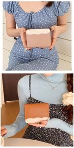Detail of leather wallets with wavy color-block design in pink and brown with zippers