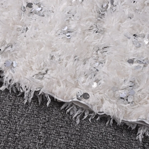 Detail shot of white feather fringe fabric with sparkling silver sequins and soft texture