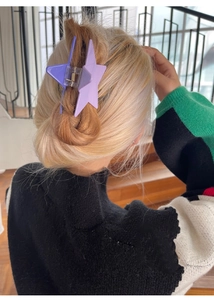 Detail of purple star claw clip with fine glitter on blonde hair in an elegant updo style