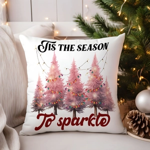 Detail of white Christmas pillow cover with pink tree and 'Tis the season' text