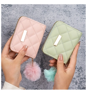 Dettaglio di portafogli trapuntati in rosa e verde con ciondoli decorativi in peluche