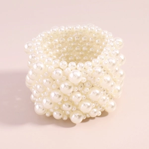 Detailed macro view of woven multi-layered white pearl wide bracelet with rich texture