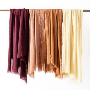 Hanging cotton linen scarves in burgundy, rose pink, rust orange and beige with fringes