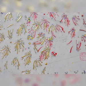 Vista macro di adesivi per nail art 3D con motivi di fuochi d'artificio rosso e oro