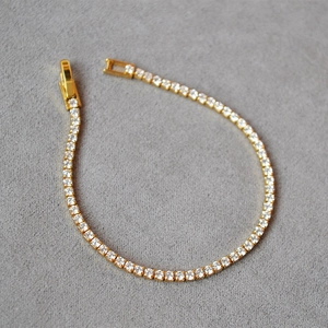 Minimalist gold plated tennis bracelet with shimmering white cubic zirconia and buckle clasp