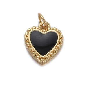 Close-up of golden heart pendant with black enamel inlay and beaded edge details