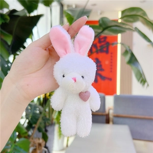 Gros plan du porte-clés lapin en peluche blanche avec cœur rose et texture douce