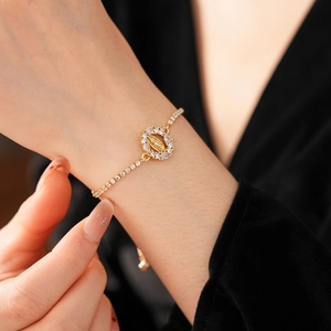 Détail d'un bracelet doré réglable avec pendentif ovale Vierge Marie en zircon