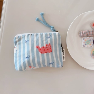 Detail of blue striped pouch featuring red polka dot cat pattern and zip closure