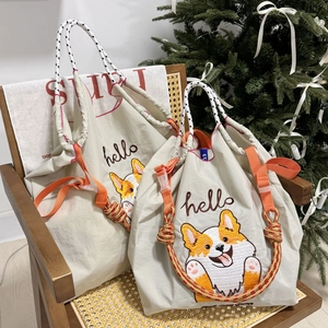 Detail of beige nylon tote bag with corgi embroidery and vibrant orange accents