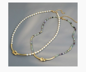 Detail of beaded necklaces with colorful glass stones and golden knot accents