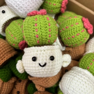 Detailed macro view of handmade crochet cactus doll in white pot with cute face