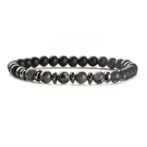 Tiger eye and matte black beaded bracelet with metal spacers on a white reflective surface