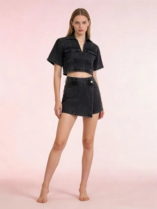 Close-up of black denim crop top with zipper and double chest pockets detail