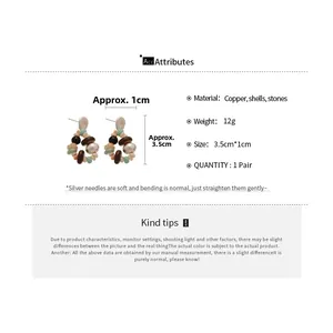 Detail view of ethnic beaded star earrings with copper, shell and stone material specs