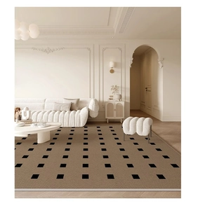 Detailed woven texture of a cream area rug with black geometric pattern in a modern living room
