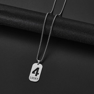 Macro shot of silver stainless steel lucky number 4 pendant on black cylinder stand