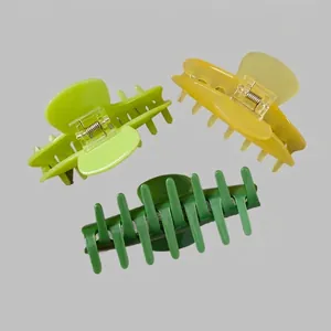 Three acetate shark hair claws in green and yellow colors for thick hair styling