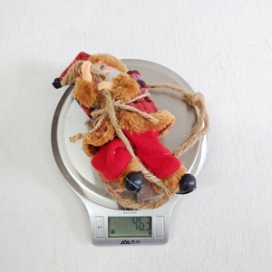 Macro shot of resin Santa Claus climbing rope decoration on a scale weighing 46.3g