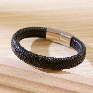 Close-up of black braided leather men's bracelet with silver magnetic stainless steel clasp