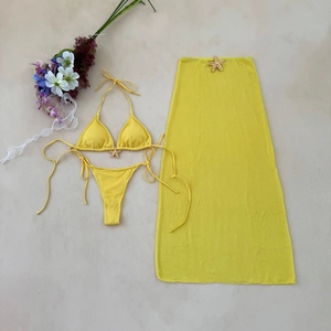 Flat lay of yellow waffle texture bikini set with starfish charms and mesh skirt