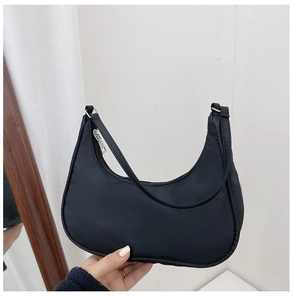 Detail of minimalist black nylon hobo bag with smooth silver metal zipper and shoulder strap