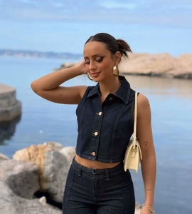 Gros plan détaillé du gilet en jean bleu foncé avec boutons métalliques et col à revers