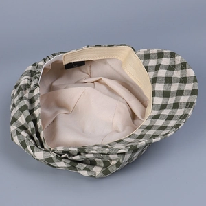 Detail view of the green plaid linen flat cap featuring soft lining and elastic sweatband