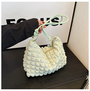 Close-up of light green bubble texture fabric and handle detail on pleated hobo bag