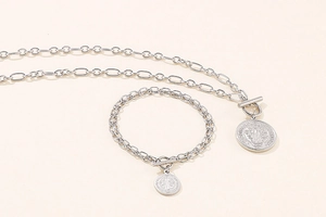 Detail of silver St. Benedict medal pendants on chain necklace and bracelet with T-bar clasp