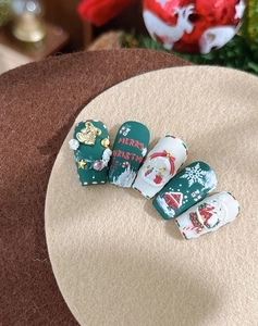 Vue macro de stickers d'ongles 3D de Noël avec motifs flocons et rennes gaufrés
