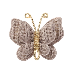 Detail of handmade crochet butterfly hair clip with golden metallic wire texture